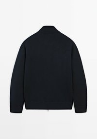 Marinblå stickad tröja med ribbad krage och ärmslut, med en slät textur och sömlös konstruktion, utan synliga stängningar eller mönster.