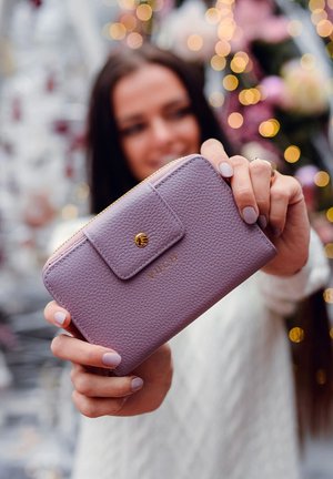 Purple leather wallet with a textured finish, gold hardware, and a snap closure. Features embossed brand name "VUCH" on the front.