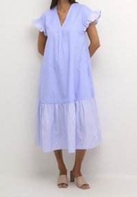 Light blue striped dress with a pleated front, flutter sleeves, and a tiered, ruffled hem. Smooth fabric with a flowy silhouette.