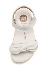 Sandal in pelle bianca con dettaglio a fiocco annodato nella parte anteriore, design con punta aperta, cinturino regolabile alla caviglia e soletta imbottita.