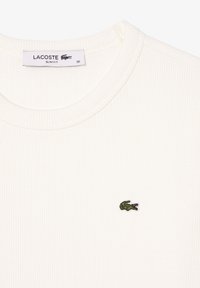 Slim-fit white ribbed T-shirt with round neckline and small green embroidered crocodile logo on the chest.