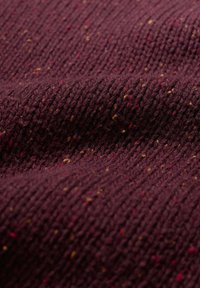 Burgundijas adīta auduma ar teksturētu virsmu, kurā ir daudzkrāsaini punkti sarkanā, dzeltenā un zaļā krāsā.