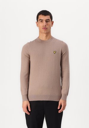 Maglione leggero marrone con maniche lunghe, scollatura rotonda, polsini e orlo a costine. Presenta un piccolo logo giallo sul lato sinistro del petto.