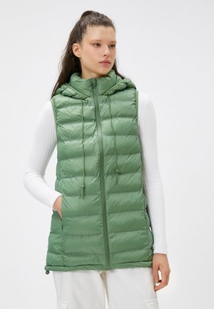 Grüne wattierte Weste mit Kapuze. Verfügt über einen Frontreißverschluss, elastische Kordelzüge und Seitentaschen. Hergestellt aus glänzendem, leichtem Stoff.