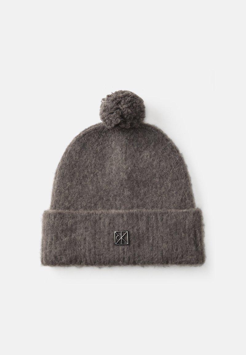 Szara dziana czapka beanie z pomponem na górze, z podwiniętym mankietem i małą naszywką z logo z przodu. Miękki, teksturowany materiał.