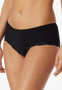 Schwarze Baumwollslips mit Spitze entlang der Kanten. Sie verfügen über einen glatten Bund und eine kleine Schleifenakzent im vorderen Mittelpunkt.