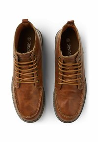 Chaussures en cuir marron avec bout rond, système de laçage et coutures contrastées. Fini texturé et languette au talon pour un enfilage facile.