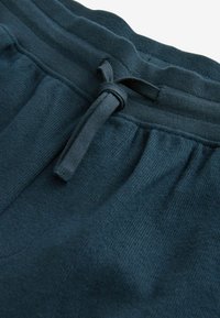 Donkerblauwe katoen loungebroeken met een gestructureerde afwerking, uitgerust met een elastische tailleband en een koorddetail aan de voorkant.
