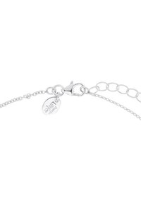 Bracciale in argento con chiusura a moschettone e un ciondolo ovale inciso con la parola "persistenza". I collegamenti sono intervallati da piccoli dettagli rotondi.