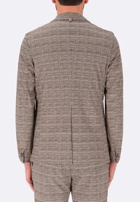 Blazer marrone a trama con un motivo sottile, apertura singola sul retro e polsini con bottoni. Vestibilità sartoriale con taglio moderno.