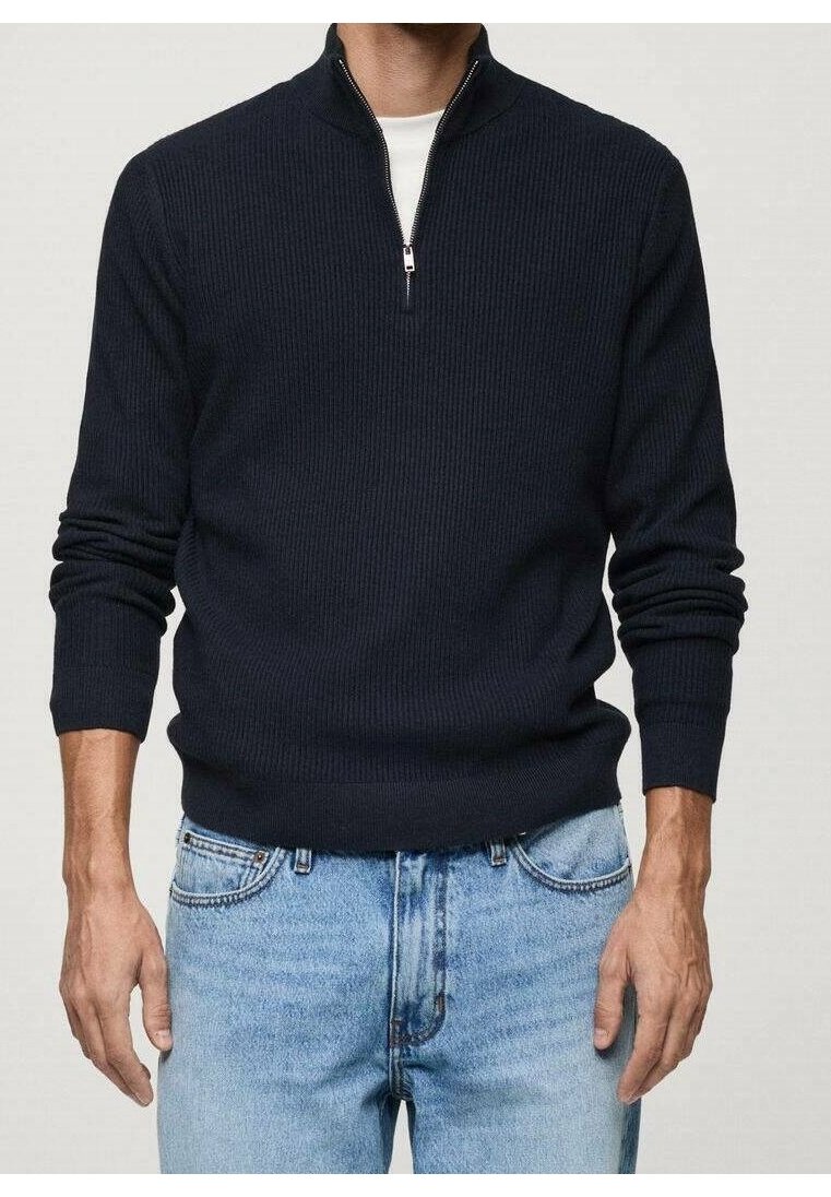 Maglione blu navy a coste con collo a mezza zip, maniche lunghe e vestibilità rilassata, abbinato a jeans in denim azzurro chiaro.