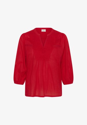 Crvena bluza od lagane tkanine s V-izrezom, naboranim prednjim dijelom i rukavima tri četvrtine. Ima ukrasne šavove za dodatni detalj.