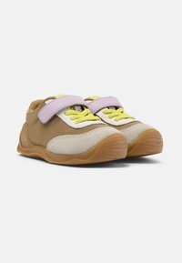 Sneaker beige e marroni con cinturino in velcro viola, lacci gialli brillanti e suola in gomma. Tessuto morbido e dettagli testurizzati sulla tomaia.