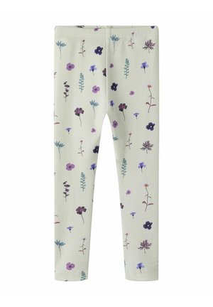 Leggings beige clair avec un motif dispersé de petites fleurs sauvages violettes, bleues et bordeaux et des tiges feuillues vertes.