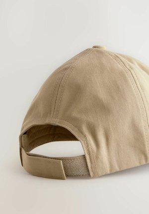 Beez värvi puuvillane müts, millel on kõver visiit ja reguleeritav rihm. Omab nähtavat ääristust ning tekstuurset viimistlust kangal.