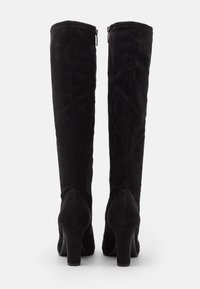 Stivali alti in suede nero con punta tonda, superficie texturizzata e tacco spesso, dotati di una cerniera sul retro per la chiusura.