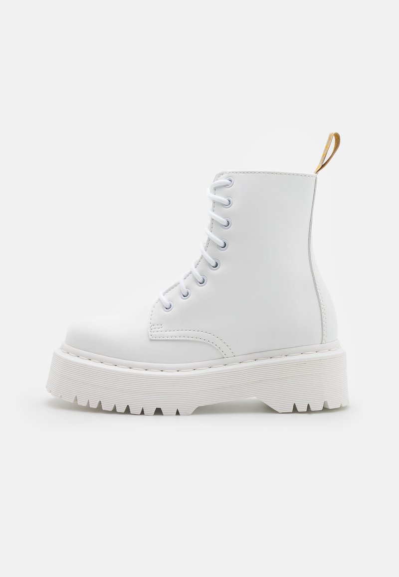 White lace-up combat boot with thick ridged platform sole and tan fabric pull tab at the back, shown in profile on white background.