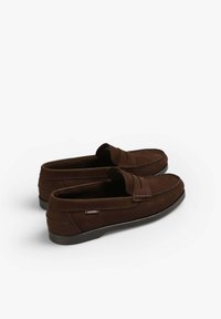 Los mocasines de ante marrón cuentan con un diseño cosido y una suela de goma de perfil bajo, con una pequeña etiqueta de logo en el lateral y un empeine texturizado.