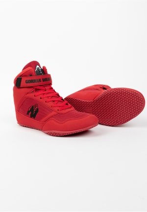 Red high-top wrestling shoes with a textured fabric upper, rubber sole, and black branding. Features a strap and a gorilla logo on the side.