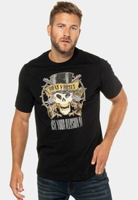 Černé bavlněné tričko s grafickým potiskem lebky s cylindrem, zkříženými zbraněmi a textem "Guns N' Roses (Use Your Illusion 91)."
