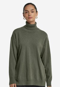 Übergroßer grüner Rollkragenpullover aus weichem Strickstoff, mit gerippten Bündchen und Saum für zusätzlichen Textur und Wärme.