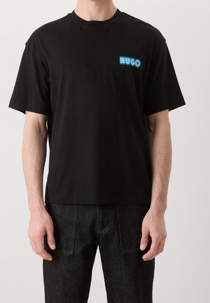 Sort bomulds-T-shirt med rund hals, der har en blå neon "HUGO"-logo på venstre bryst. Korte ærmer og en afslappet pasform.