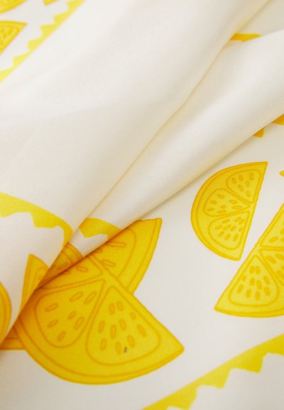 Soft fabric with a cream background, featuring bright yellow lemon slice patterns and a zigzag accent in yellow along the edge.