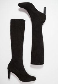Bottes cuissardes en daim noir avec un bout rond, un talon haut effilé et un design sans couture, offrant une texture douce et un minimum de détails.