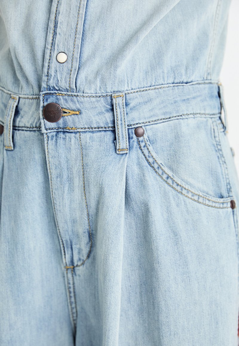 Helle blaue Jeans mit hoher Taille, ausgestattet mit einem Knopfverschluss, zwei Seitentaschen und dezenten Nähten.