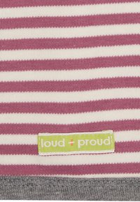 Tessuto a righe in crema chiaro e rosa tenue, con un'etichetta verde che riporta "loud + proud." L'orlo è grigio e presenta una texture liscia.