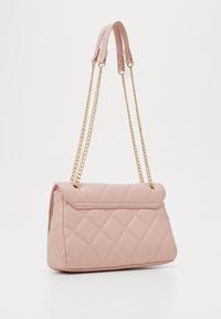 Quilted pink handbag with a fold-over flap, chain straps, and gold hardware accents. Material is smooth, offering a soft texture and clean lines.