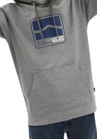 Felpa grigia con cappuccio e tasca a marsupio, con logo quadrato blu e testo. Realizzata in tessuto morbido, presenta cappuccio con coulisse e polsini a costine.