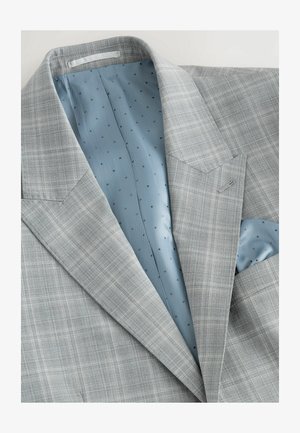 Gråternet jakkesætjakke med spidse klapper, lyseblå foret med små sorte prikker, og en enkelt brystlomme med et matchende lommetørklæde.