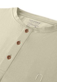 Hellgrünes, geripptes Langarmshirt mit rundem Halsausschnitt, vier braunen Knöpfen und einem gestickten Logodetail am Saum.