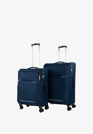 Dos maletas de concha blanda azul marino con asas retráctiles y cuatro ruedas giratorias, colocadas una al lado de la otra sobre un fondo blanco.