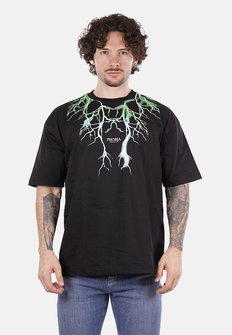 T-shirt nera in cotone con maniche corte, caratterizzata da un design grafico a forma di fulmine verde e bianco, con il marchio "PHOBIA" sotto il graphic.