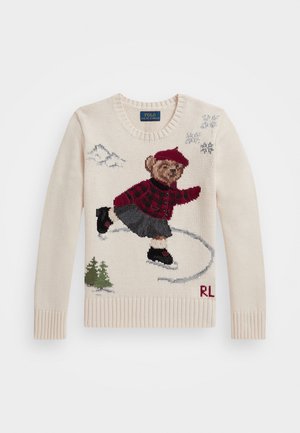 Maglione lavorato a maglia in crema con un design di un orso che pattina, dotato di una giacca a quadri rossi, una gonna nera e accenti di fiocchi di neve. Polsini e orlo a costine.