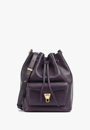 Borsa a secchiello in pelle viola con finitura strutturata, tracolla regolabile, chiusura con coulisse e una tasca frontale con fibbia dorata.