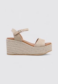 Sandalia de cuña beige con parte superior de ante, diseño de punta abierta, correa en el tobillo con hebilla y plataforma envuelta en yute para mayor textura.