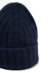 Gorro de lana navy con textura acanalada y parte superior cónica. Presenta un borde doblado, material suave y grueso para mayor calidez.