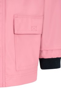 Giacca impermeabile rosa con tasca sul petto, polsini neri a coste e texture liscia. Presenta dettagli di cucitura visibili.