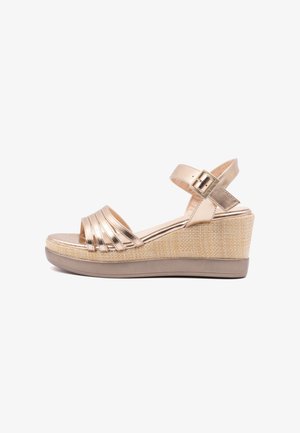 Metallic gouden wedge sandaal met een tekstuur van beige platform, open teen en een verstelbare enkelband met een gesp. Gestreept ontwerp op de voorkant.