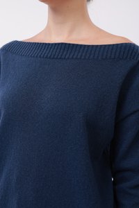 Marineblå strikkegenser med bred off-shoulder hals, ribbestrikket krage og myk tekstur, som viser den øverste delen av plagget.