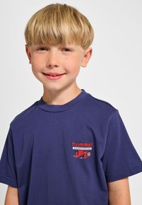 Marineblå t-shirt lavet af bomuld med rund hals, prydet med et farverigt "hummel SPORTSWEAR" logo på venstre brystområde.