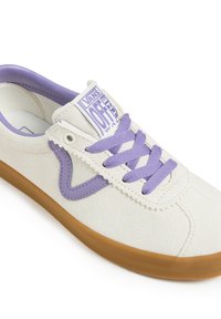 White suede sneaker with purple accents, featuring a rounded toe, flat purple laces, and a textured rubber sole. Branding at the tongue.
