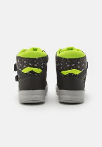 Sneakers alte nere con rivestimento in rete verde lime, dettagli a motivo stelle e cinturini con chiusura a strappo; dotati di suola in gomma grigia.