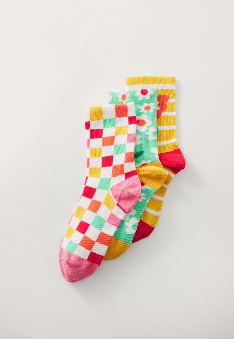 Tre par sokker: en med et multicolorternet mønster, en med blomsterdesign på grøn baggrund, og en med gule striber.