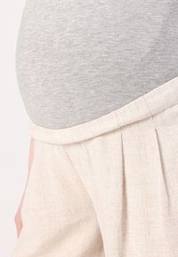 Jasnoszare lniane spodnie z plisami w talii, zestawione z fiolkowym, dopasowanym topem, prezentującym gładką teksturę i casualowy design.