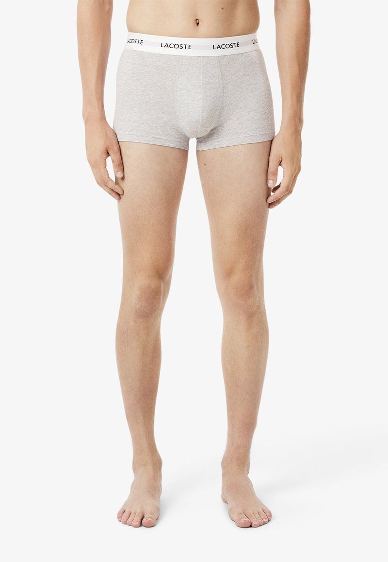 Graue Baumwoll-Boxershorts mit einem schwarz-weißen, gebrandeten Bund. Sie verfügen über ein tailliertes Design und eine glatte Textur.