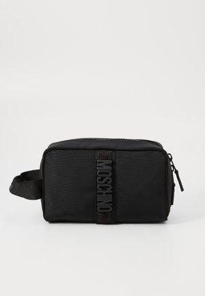 Black nylon toiletry bag featuring a textured surface, zip closure, side handle, and a raised logo prominently displayed on the front.